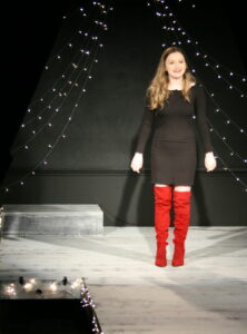 The red boots on Bella Allison take center stage - she's performing a song from Kinky Boots at the 2019 Season Announcement Cabaret. Sparkling lights are the backdrop