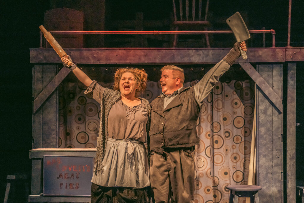 Mrs. Lovett and Mr. Todd hold their implements high! 